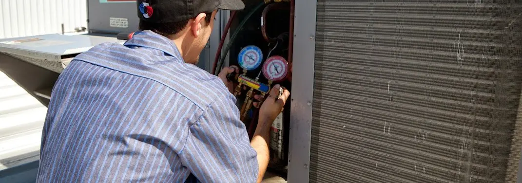 HVAC technician servicing a condenser unit in Grandview Heights